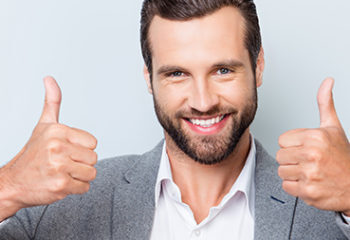 Close Up Photo Of Glad With Beaming Smile Young Man In Gray Suit